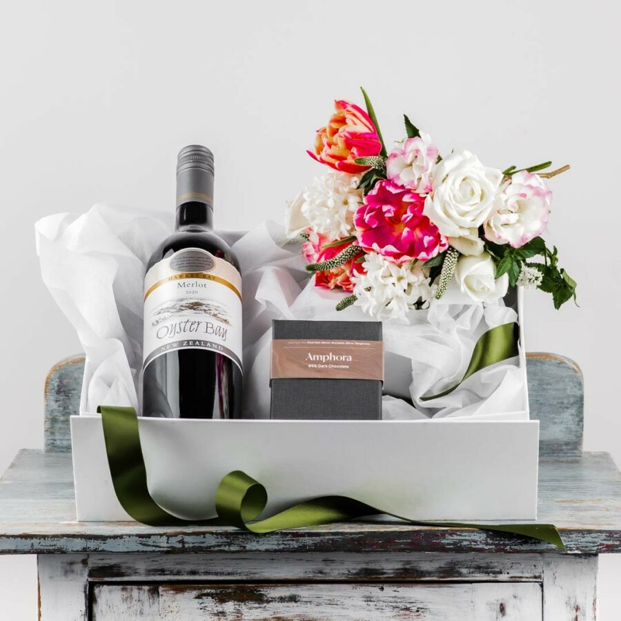 sturdy white box with magnetic lid filled with Merlot wine bottle box of chocolates and fresh flower posy